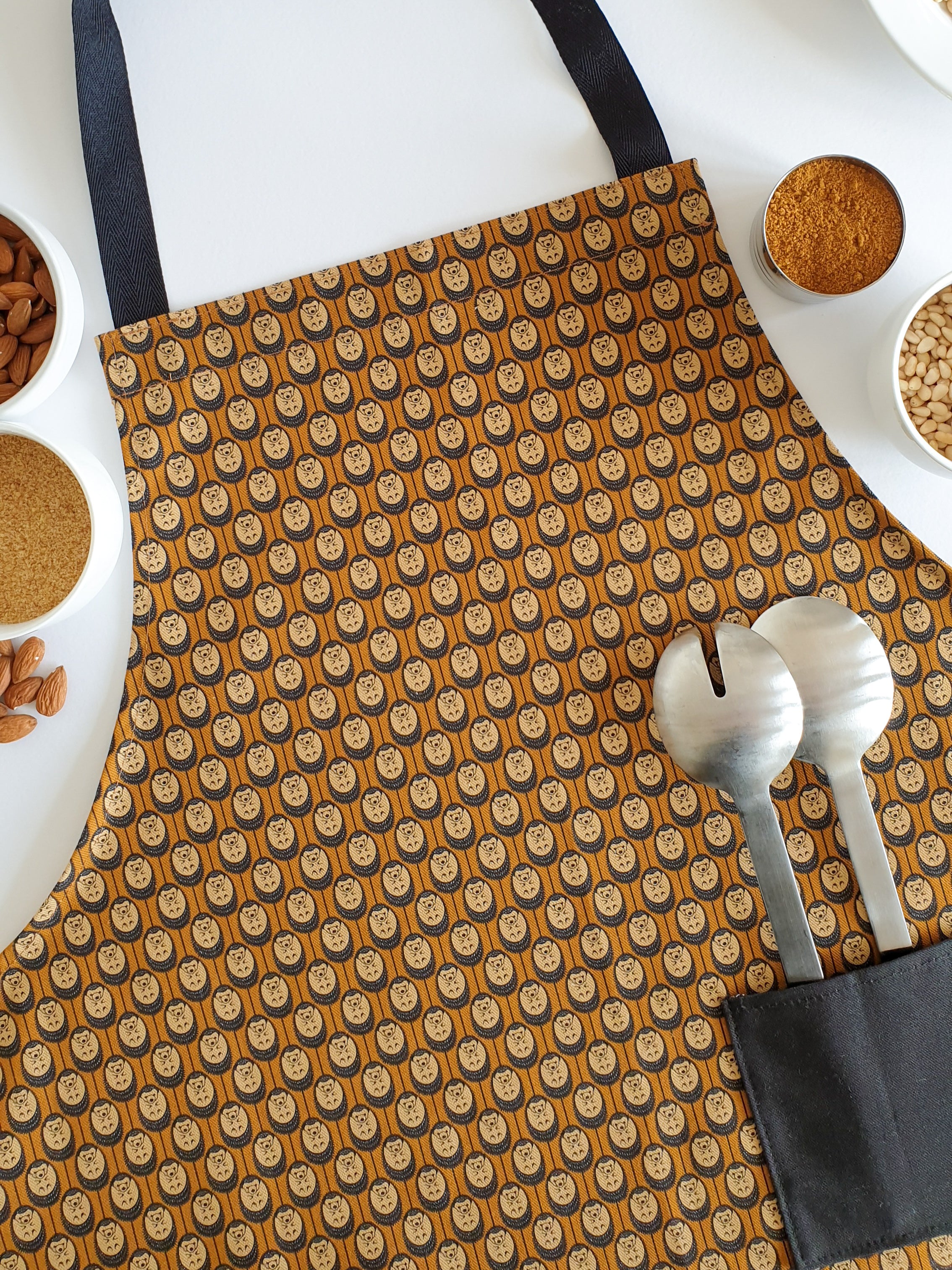 Organic cotton autumn hedgehog apron – designed by Hannah Issi and handmade in the UK. Sustainable, stylish kitchen textile pictured with cooking ingredients