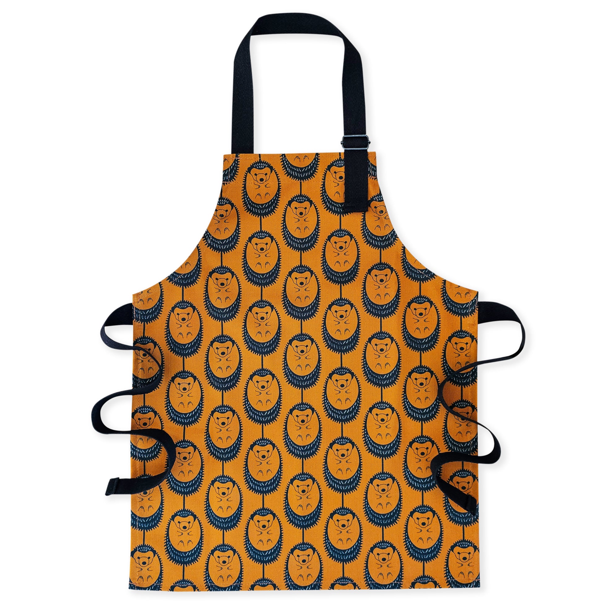 Organic cotton children’s terracotta hedgehog apron – handmade in the UK by Hannah Issi. Fun, sustainable kitchen accessory for kids. Ideal for messy play and cooking. Cut-out image on white background.