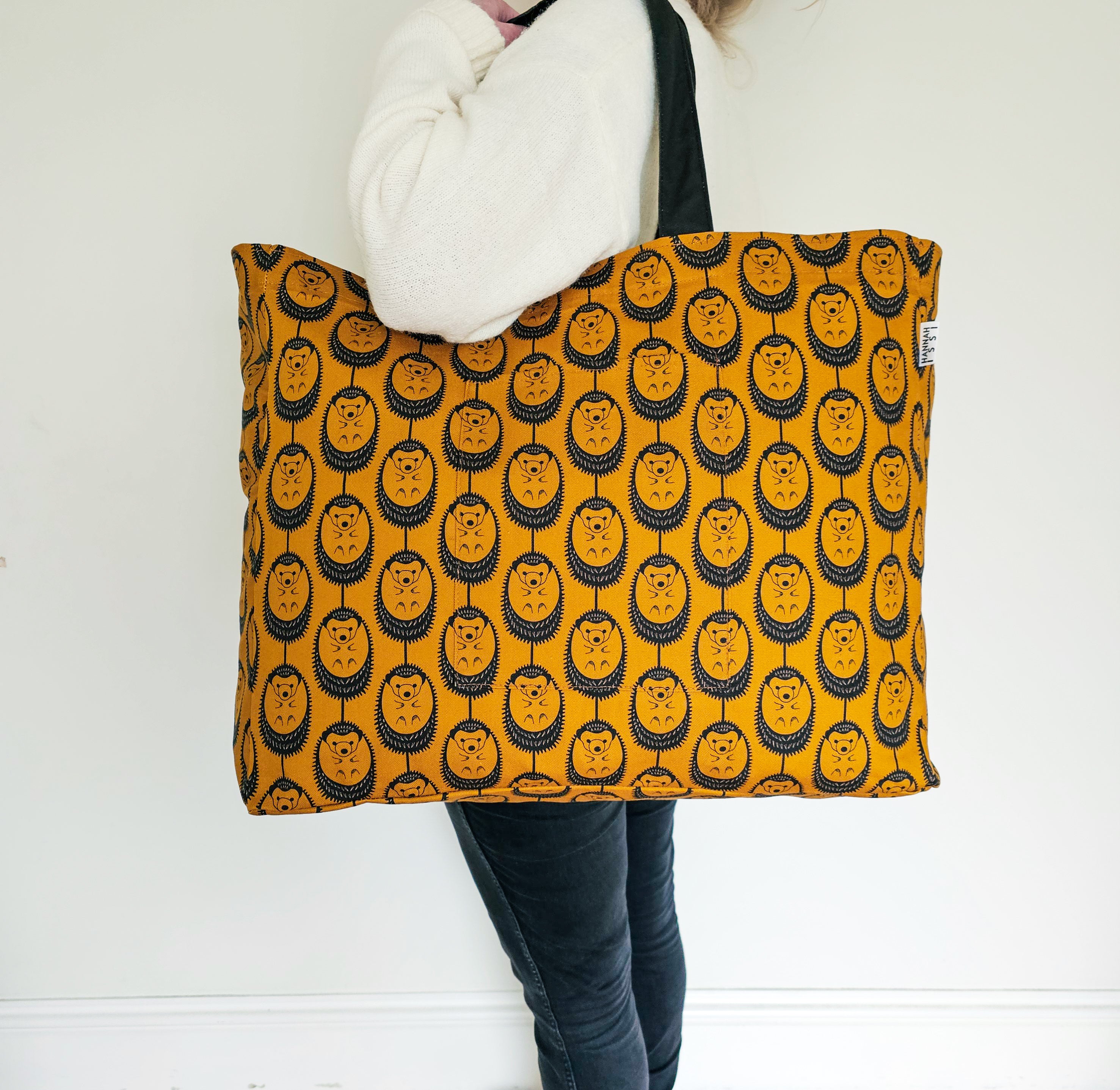 Organic cotton Ochre Hedgehog oversized shoulder bag – large, roomy design handmade in the UK by Hannah Issi. Stylish and sustainable. Bag is shown modelled on shoulder with neutral background.