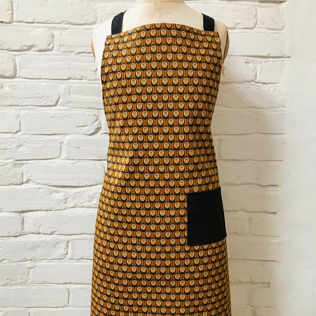 Hedgehog Patterned apron on a mannequin against a white brick wall background