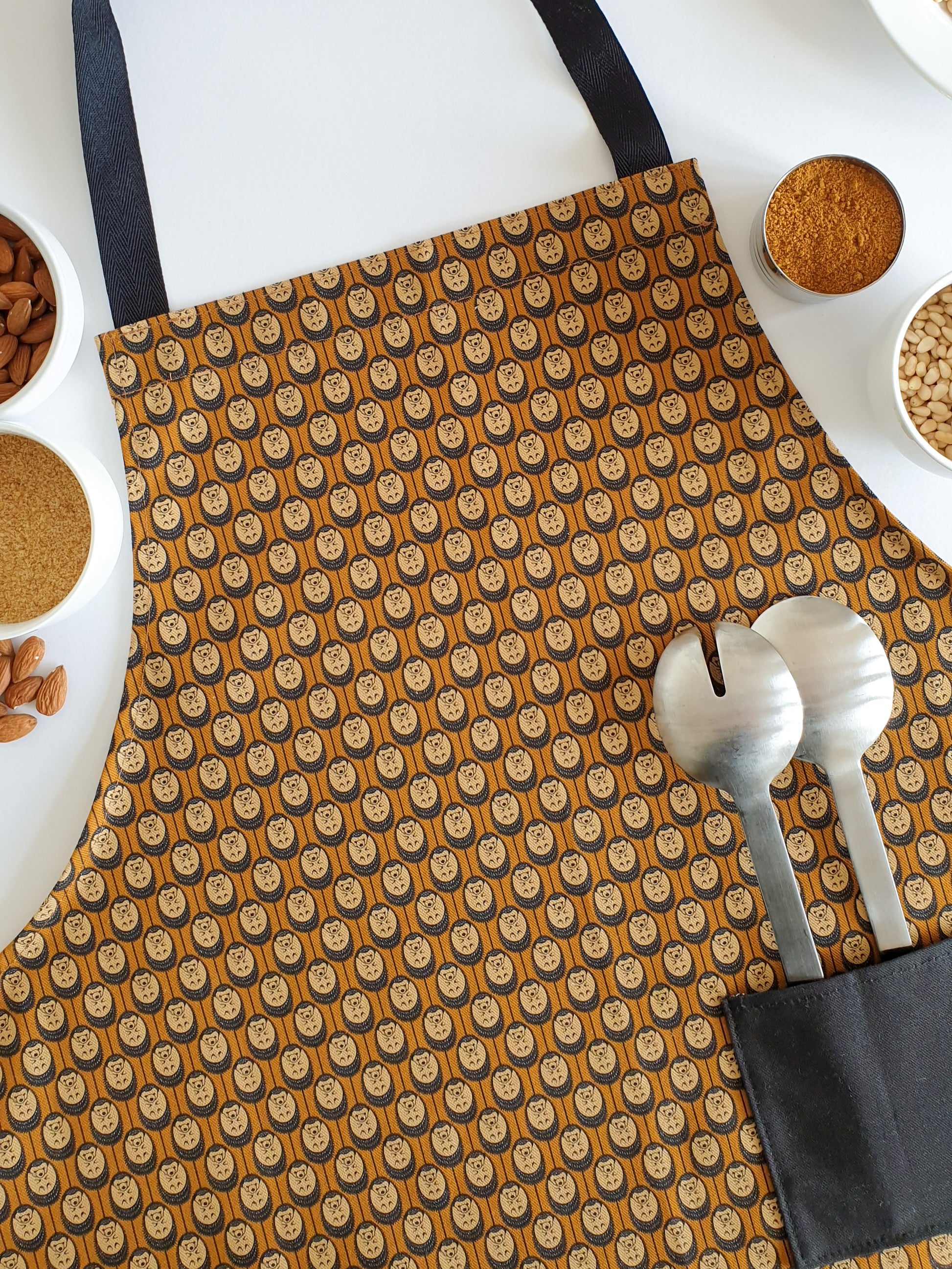 Organic cotton autumn hedgehog apron – designed by Hannah Issi and handmade in the UK. Sustainable, stylish kitchen textile pictured with cooking ingredients