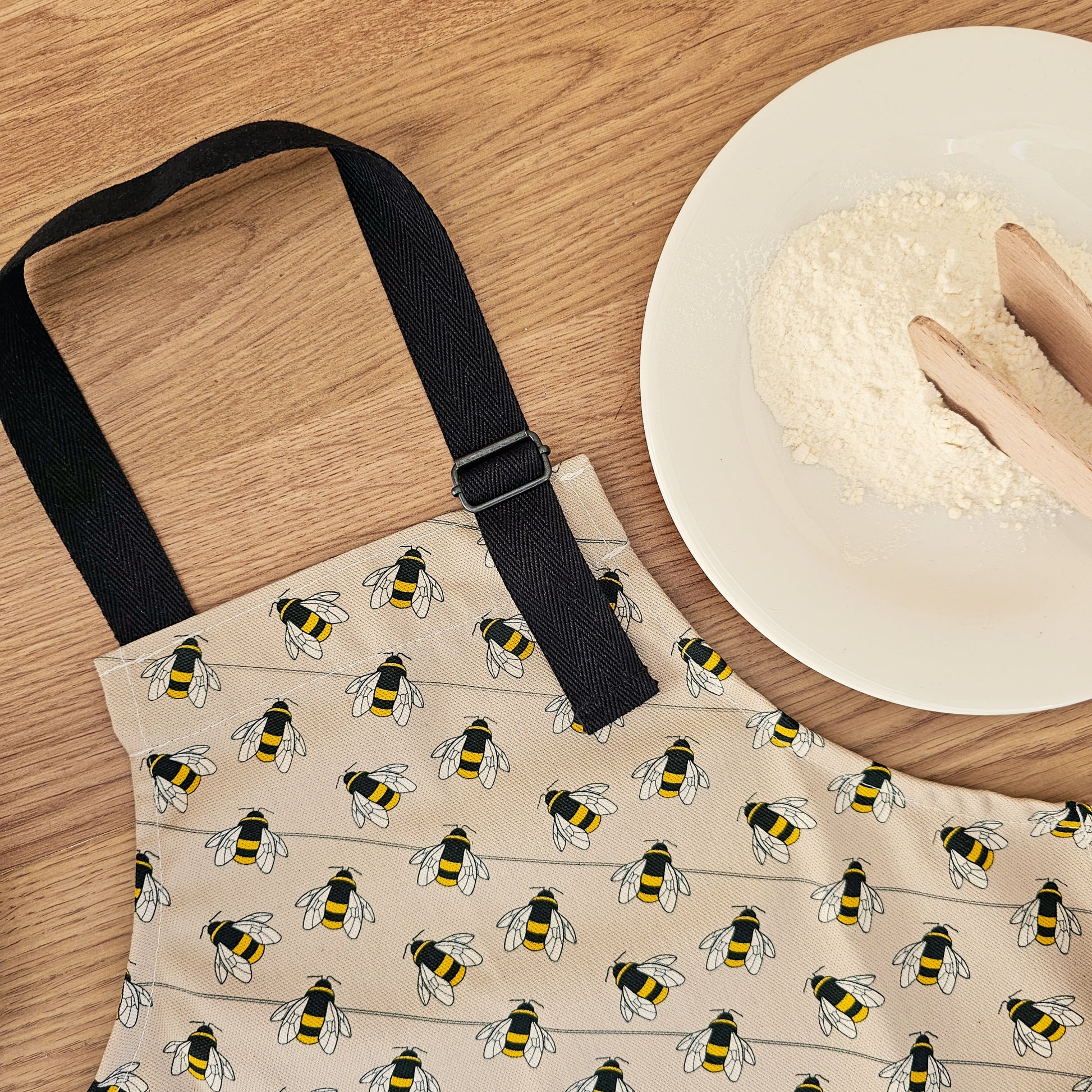 Organic cotton children’s bee apron – handmade in the UK by Hannah Issi. Fun, sustainable kitchen accessory for kids. Close-up photo showing adjustable neck strap.