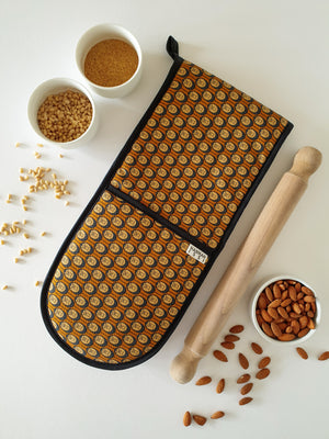 Organic cotton autumn hedgehog double oven glove – handmade in the UK by Hannah Issi. Stylish, heat-safe kitchen accessory. Lifestyle image with white background and cooking ingredients.