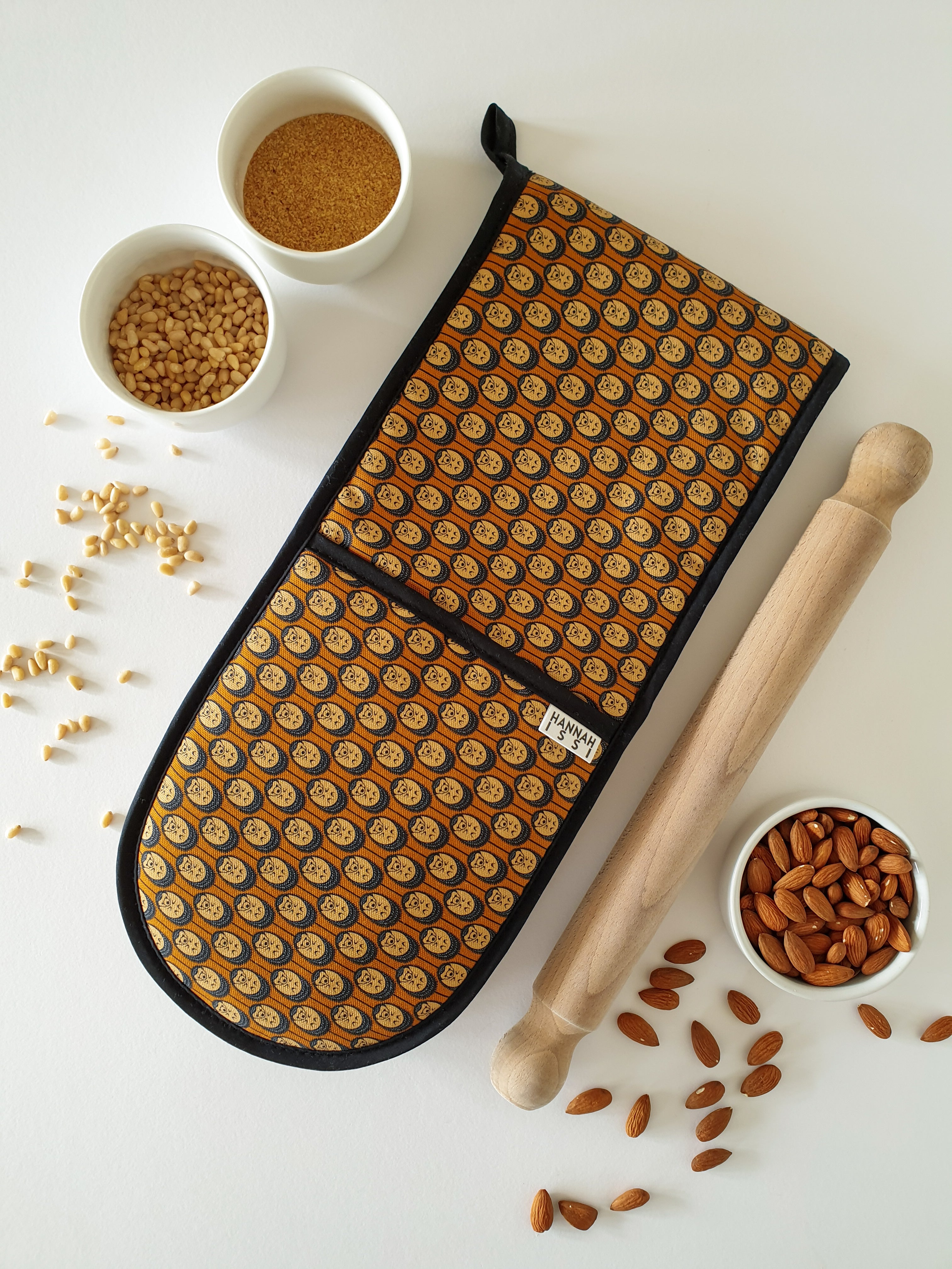 Organic cotton autumn hedgehog double oven glove – handmade in the UK by Hannah Issi. Stylish, heat-safe kitchen accessory. Lifestyle image with white background and cooking ingredients.