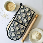 Organic cotton grey & white hedgehog double oven glove – handmade in the UK by Hannah Issi. Stylish, heat-safe kitchen accessory. Lifestyle image with cooking ingredients and rolling pin on white background.