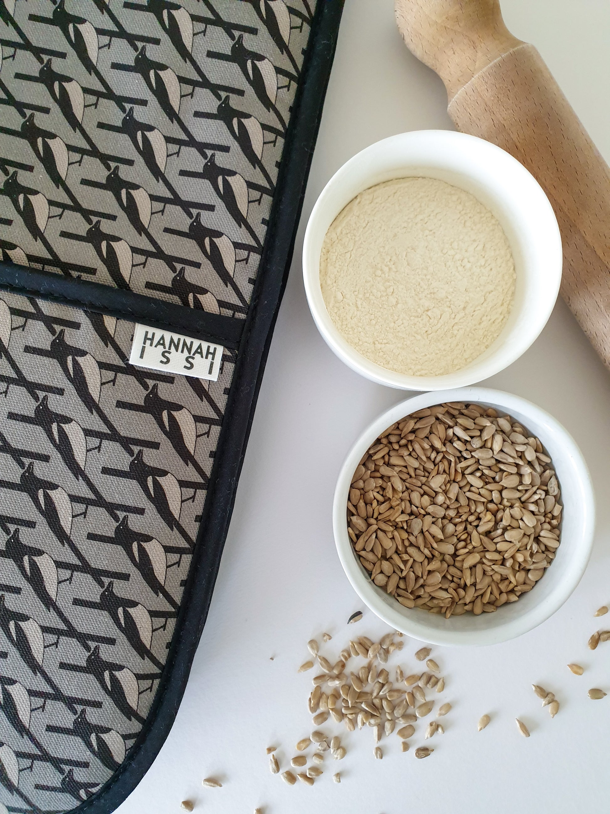 Organic cotton grey magpie double oven glove – handmade in the UK by Hannah Issi. Stylish, heat-safe kitchen accessory. Close-up lifestyle image with white background and cooking ingredients.