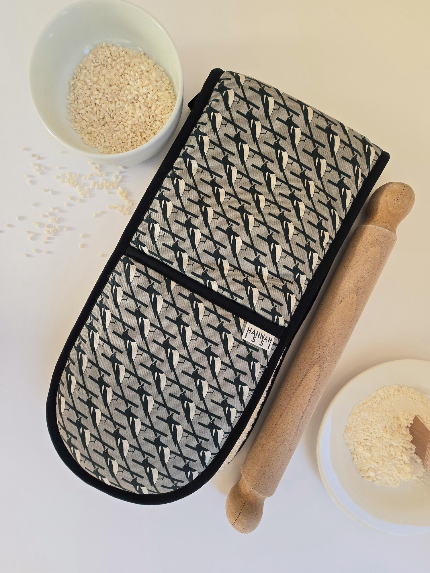 Organic cotton grey magpie double oven glove – handmade in the UK by Hannah Issi. Stylish, heat-safe kitchen accessory. Lifestyle image with white background and cooking ingredients.
