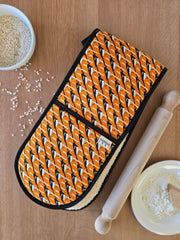 Organic cotton orange magpie double oven glove – handmade in the UK by Hannah Issi. Stylish, heat-safe kitchen accessory. Lifestyle image with wooden background and cooking ingredients.
