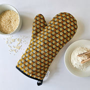 Organic cotton autumn hedgehog luxury oven glove – handmade in the UK by Hannah Issi. Stylish, heat-safe kitchen accessory. Lifestyle image with white background and cooking ingredients.