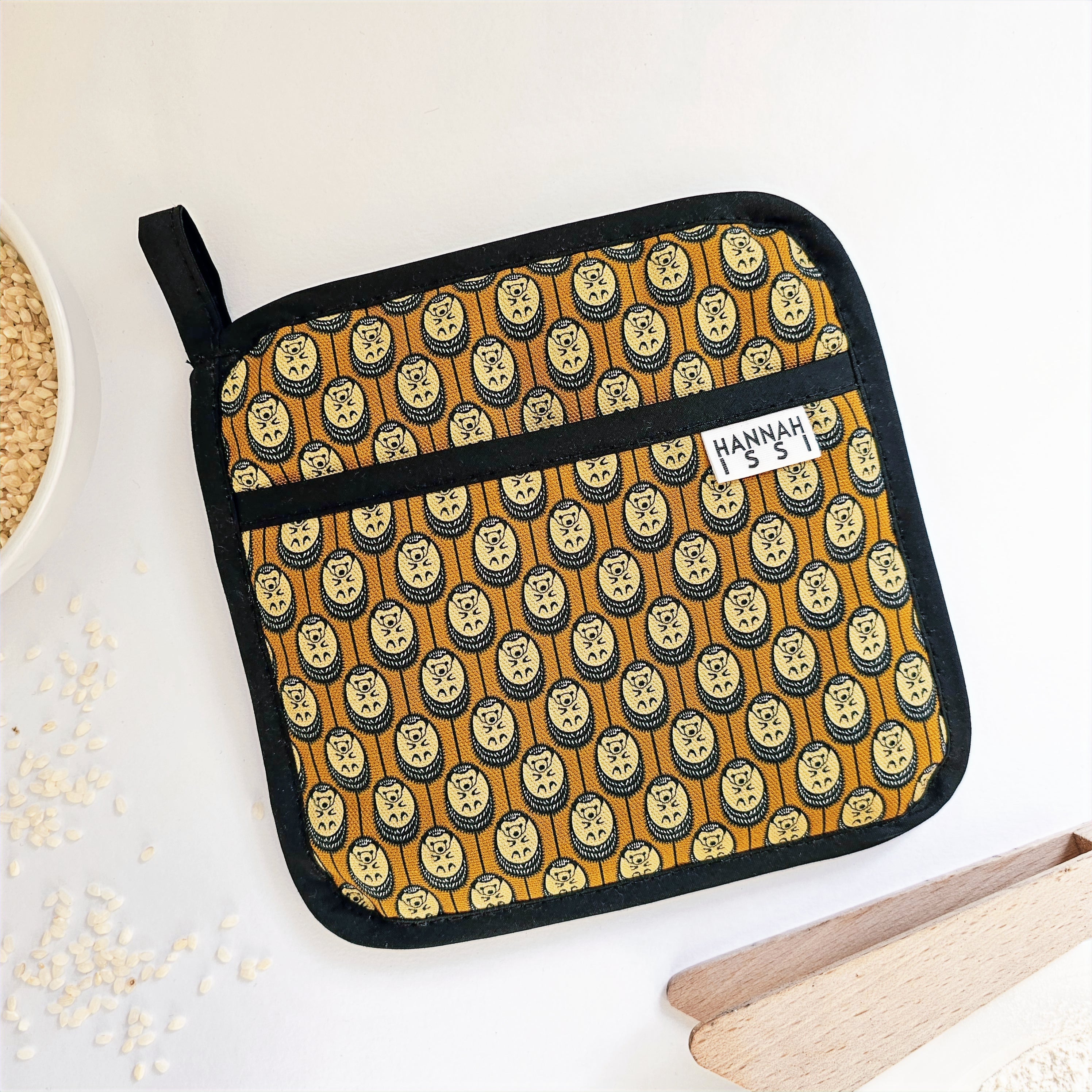 Organic cotton autumn Hedgehog pot grab – heat-safe kitchen handle cover by Hannah Issi, handmade in the UK. Stylish and functional.  Lifestyle image on white background with kitchen accessories.