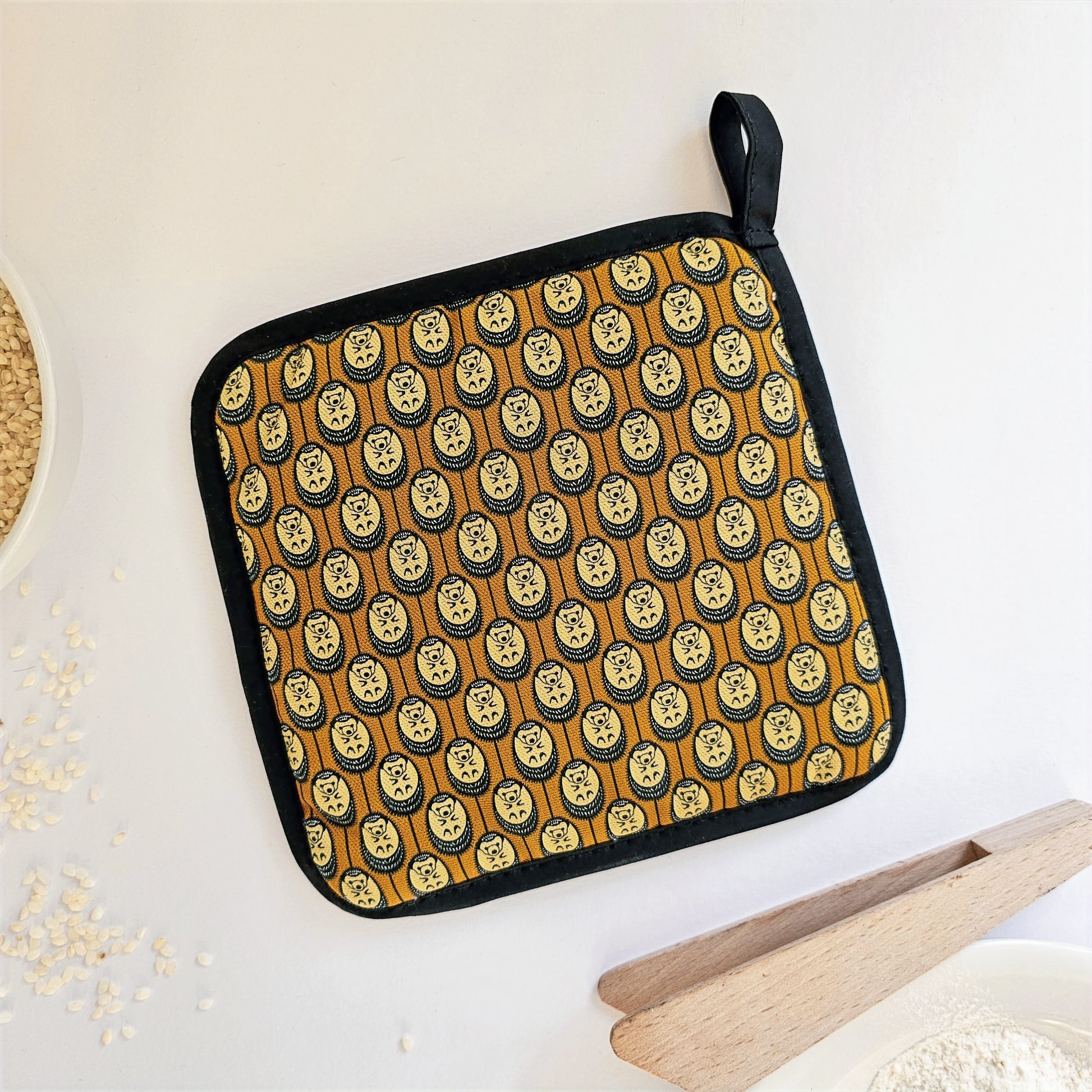 Organic cotton autumn Hedgehog pot grab – heat-safe kitchen handle cover by Hannah Issi, handmade in the UK. Stylish and functional. Image shows reverse on white background  with kitchen accessories. 