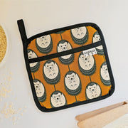 Organic cotton Brown & White Hedgehog pot grab – heat-safe kitchen handle cover by Hannah Issi, handmade in the UK. Stylish and functional. Lifestyle image on white background with kitchen accessories. 