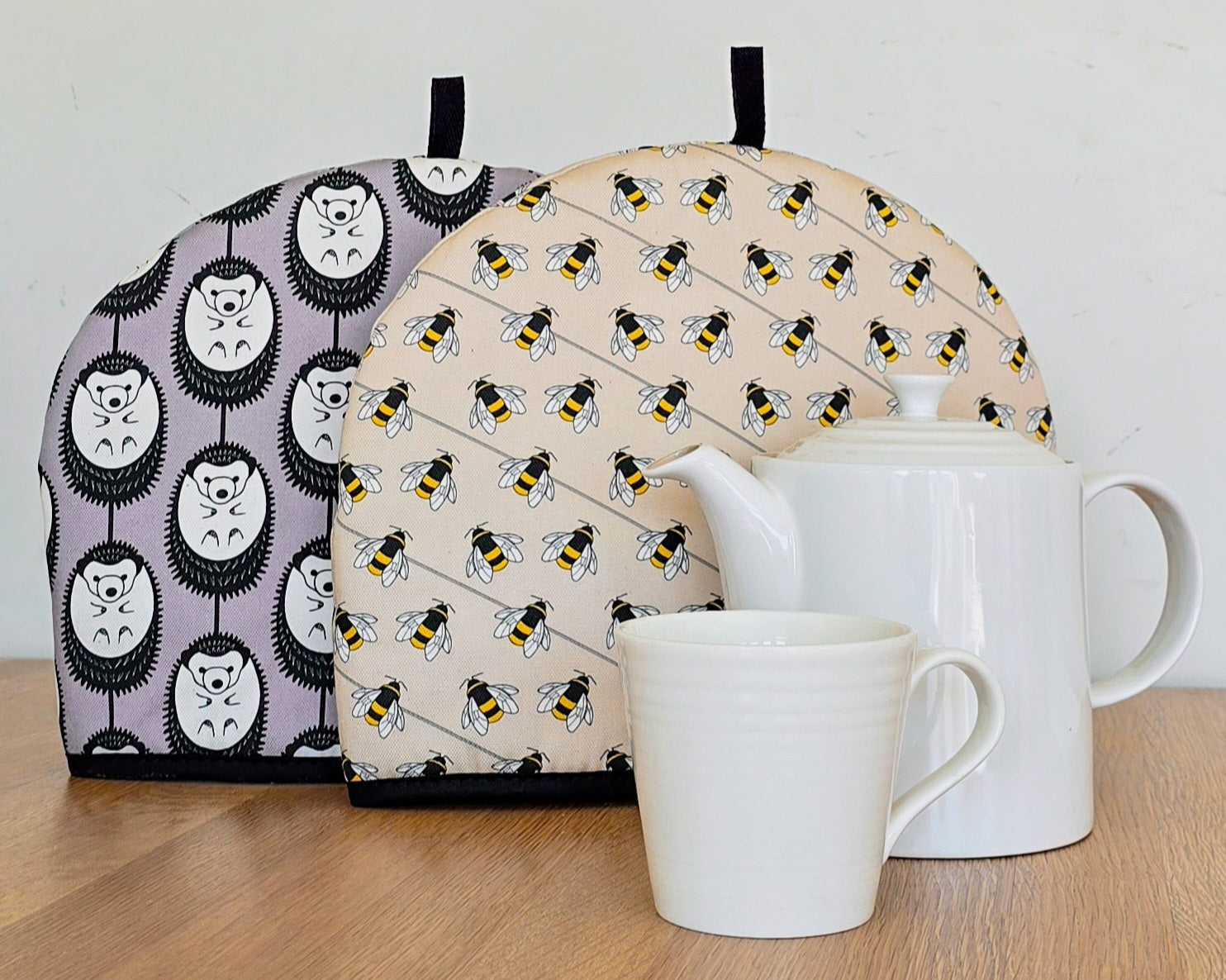 Organic cotton hedgehog and bee tea cosies by Hannah Issi – handmade in the UK. Stylish, sustainable kitchen accessories.