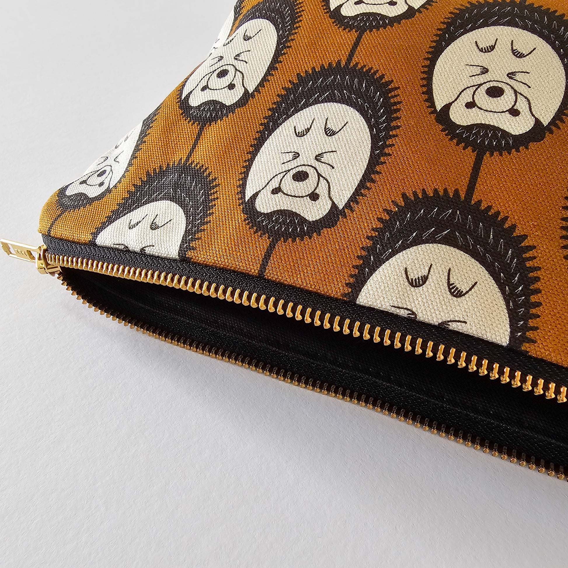 Organic cotton hedgehog zip bag – handmade in the UK by Hannah Issi. Brown & white hedgehog print, versatile and sustainable accessory. Close-up pf bag with neutral background.